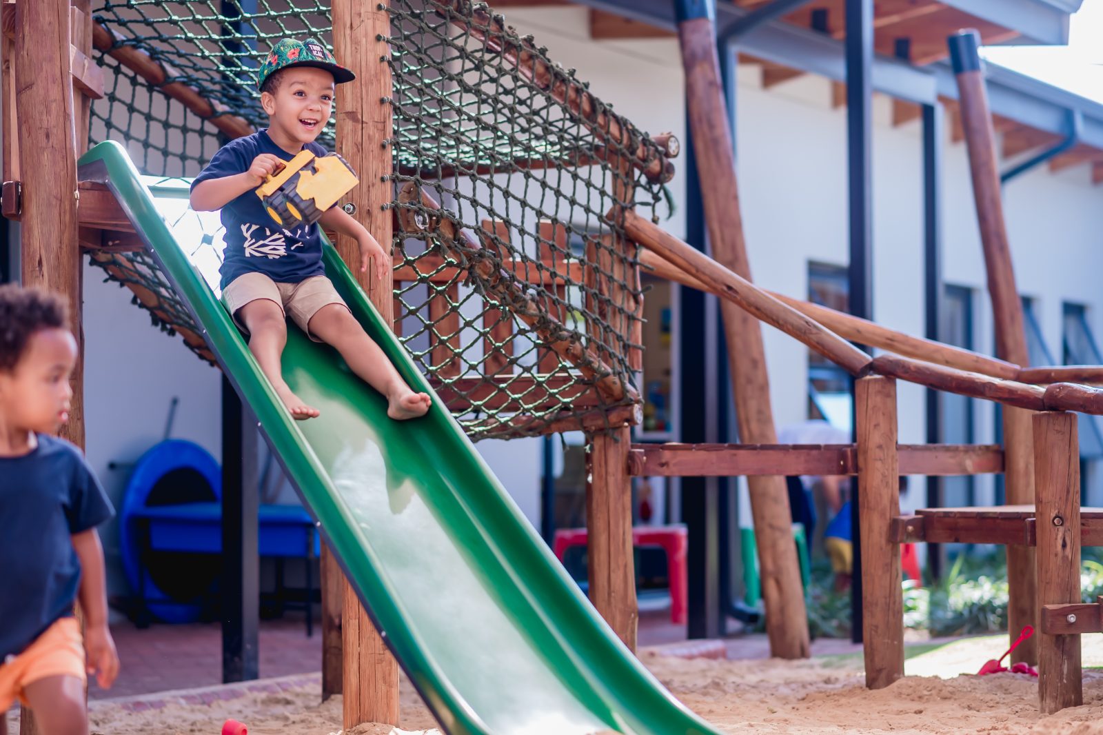 A Preschool child playing on the slide in the Syringa campus garden