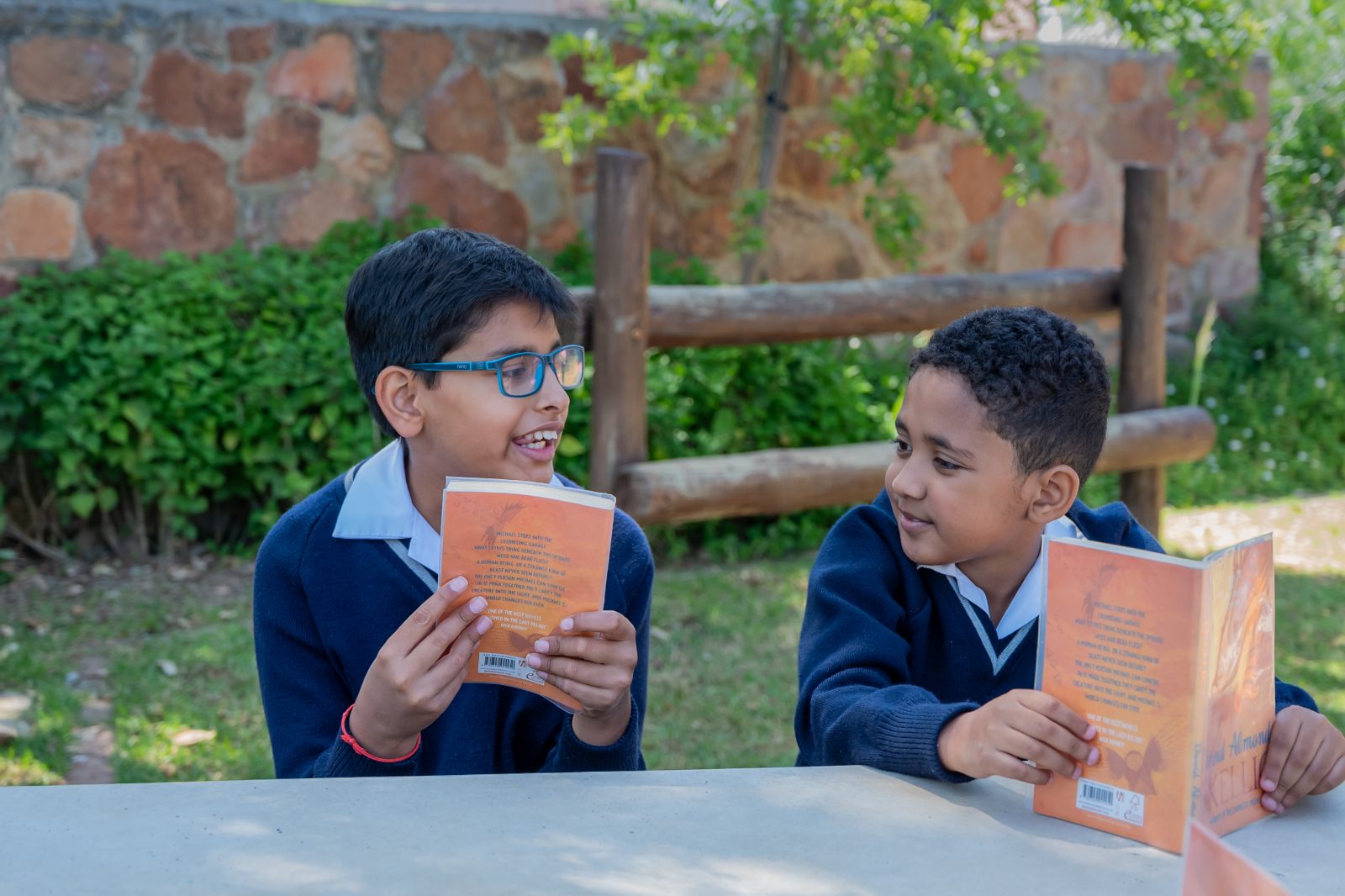 Two Senior Prep boys reading together at a bench on the Chartwell campus